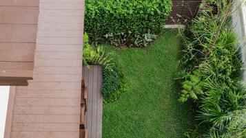 Un jardin sur le toit doté d’une terrasse en bois, d’un espace salon et d’une végétation luxuriante.
