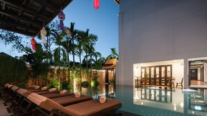 A poolside area with lounge chairs and a pool. - El Barrio Lanna (Chiang Mai)