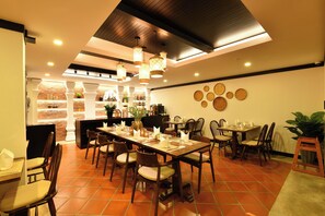 A restaurant with a brick wall, wooden tables, and chairs. - El Barrio Lanna (Chiang Mai)
