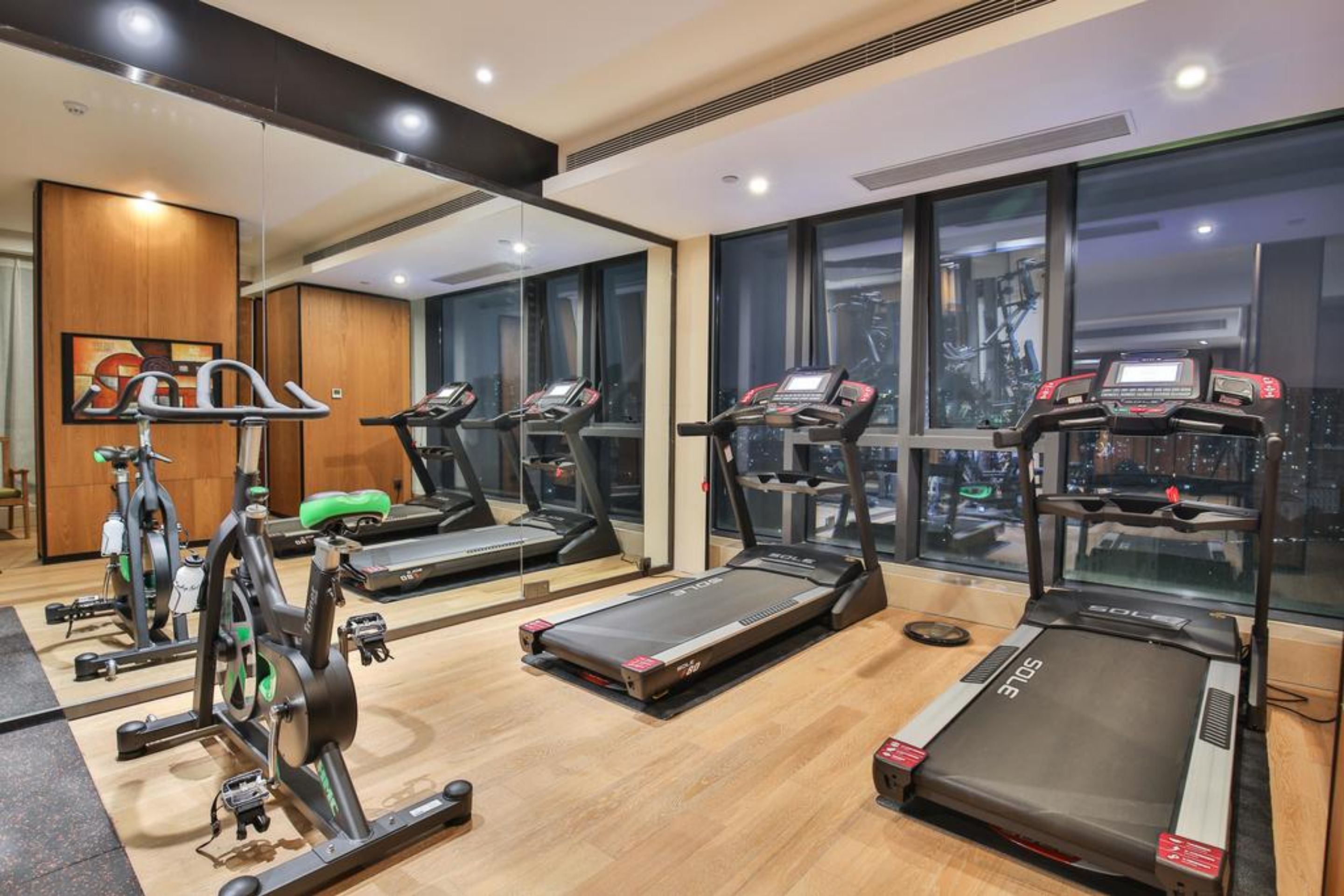 Une salle de sport équipée de tapis de course, de vélos d’appartement et d’appareils de musculation elliptique.