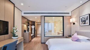 A modern hotel room with a bed, desk, and a walk-in closet. - SSAW Boutique Wenzhou Meimei Square Hotel (Wenzhou)