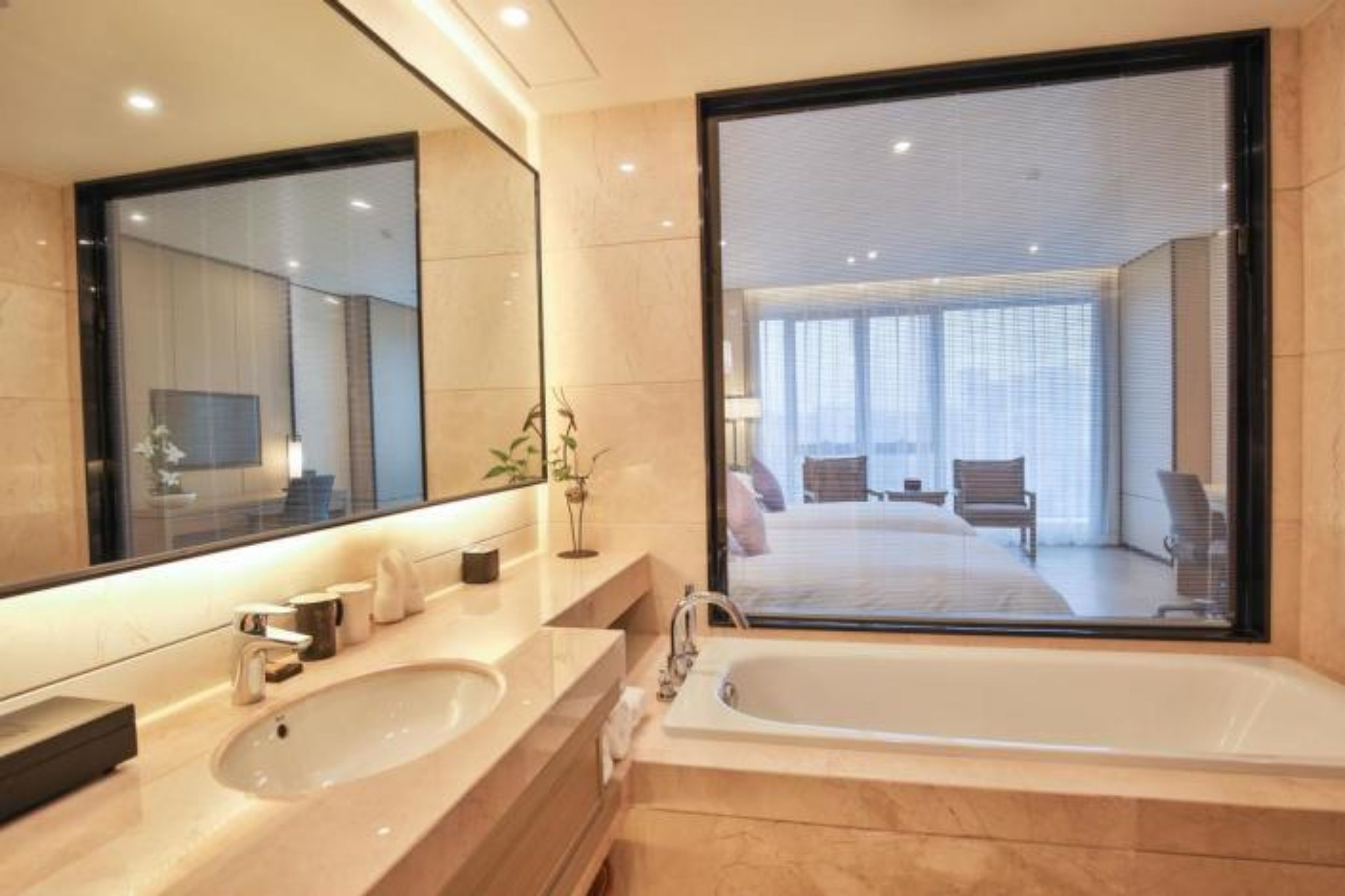 Un bagno moderno con uno specchio grande, due lavabi e una vasca.
