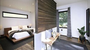 Un dormitorio moderno con cama, mesita de noche y un gran ventanal con cortinas.