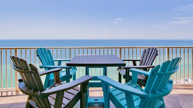Une terrasse avec une table et des chaises, donnant sur l’océan.