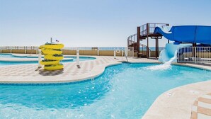 Un espace piscine équipé d’un toboggan et de bouées gonflables.