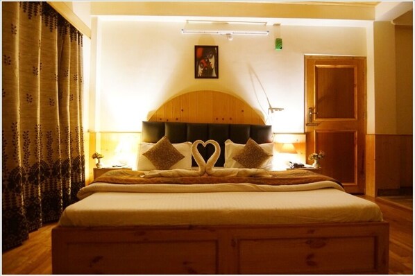 Cozy retreat with a large bed, wooden headboard, and a bedside table with a lamp.