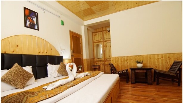 Ein Hotelzimmer mit einem großen Bett, einem Holzkopfstück und Holzboden.