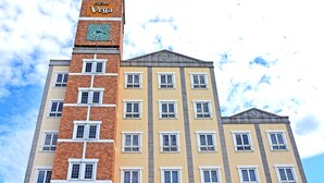 Een meerlaags gebouw met een klokkentoren, met een combinatie van baksteen en geverfde gevels.