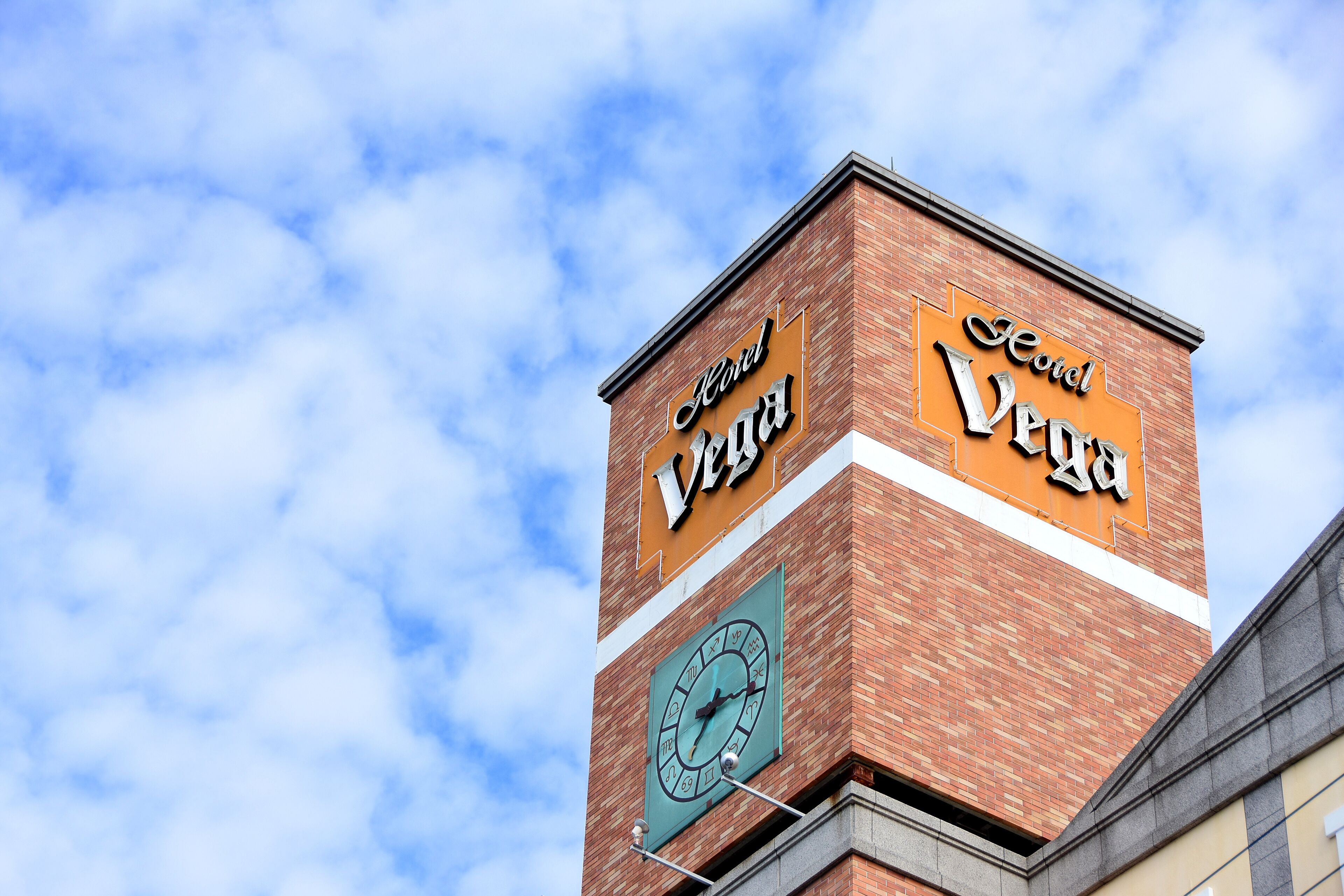 Ein Hotelschild mit einer darunter befindlichen Uhr.