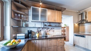 A modern kitchen with wooden cabinets, a central island, and a built-in dishwasher. - Holiday home with heated outdoor swimming pool up to 12 persons (Cluj-Napoca)