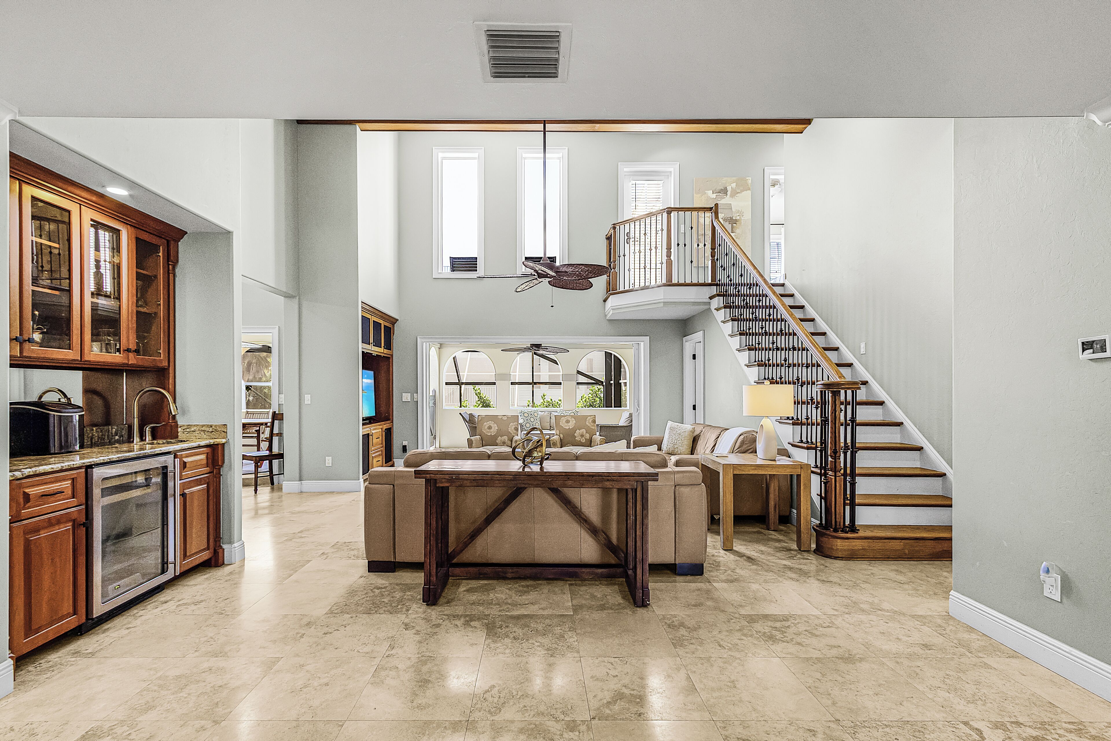 A spacious living area with a kitchen, a dining table, a sofa, and a staircase.