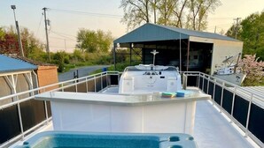 Un jacuzzi con terraza de madera, un área techada y una bandera.