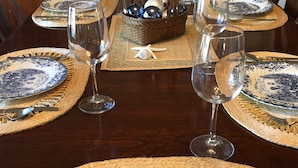 A dining table set with blue and white plates, silverware, and wine glasses. - Quintessential New England Home on Private Beach  (Westerly)