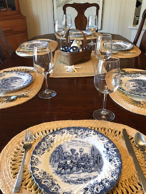 Formal dining area with a beautifully set table, complete with fine china and crystal glassware.