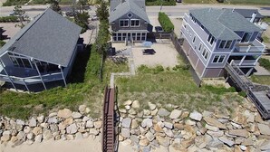 A residential area with houses, a paved driveway, and a stone wall. - Quintessential New England Home on Private Beach  (Westerly)