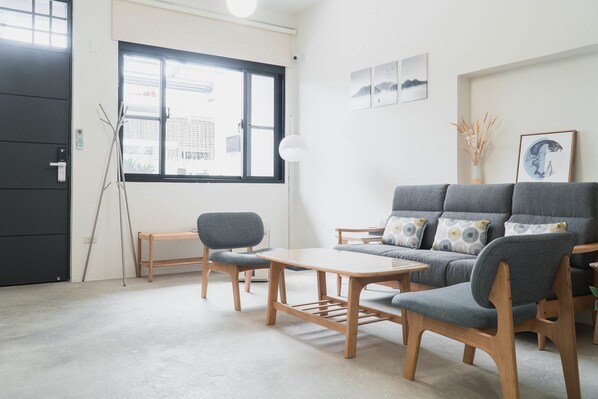 Uma sala de estar moderna com um sofá, uma mesa de centro e duas poltronas.