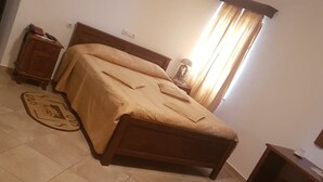 A bedroom with a bed, a nightstand, a desk, and a window with curtains. - Hotel Etrusco (Gherla)