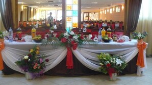 A banquet hall with tables set for a formal event, adorned with floral centerpieces and tableware. - Hotel Etrusco (Gherla)