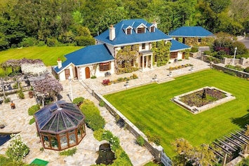 Aerial view of home, patio with summer home, and fire pit