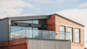 A modern building with a glass balcony and large windows.