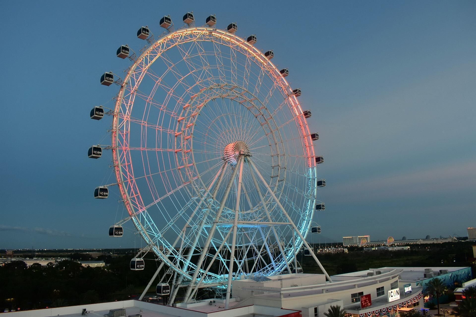 A large Ferris wheel with cabins labeled "ICON" at a theme park.