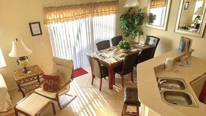 A compact living space with a dining area, kitchen, and seating area. - Fantastic house next to Disney. Enjoy private heated pool! (Kissimmee)