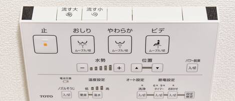 A control panel with Japanese instructions for a water fountain, including stop, spray, and bidet functions.