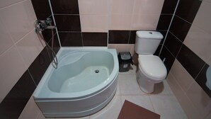 A bathroom with a bathtub, toilet, and a small trash bin. - Hotel Tsiskari (Telavi)