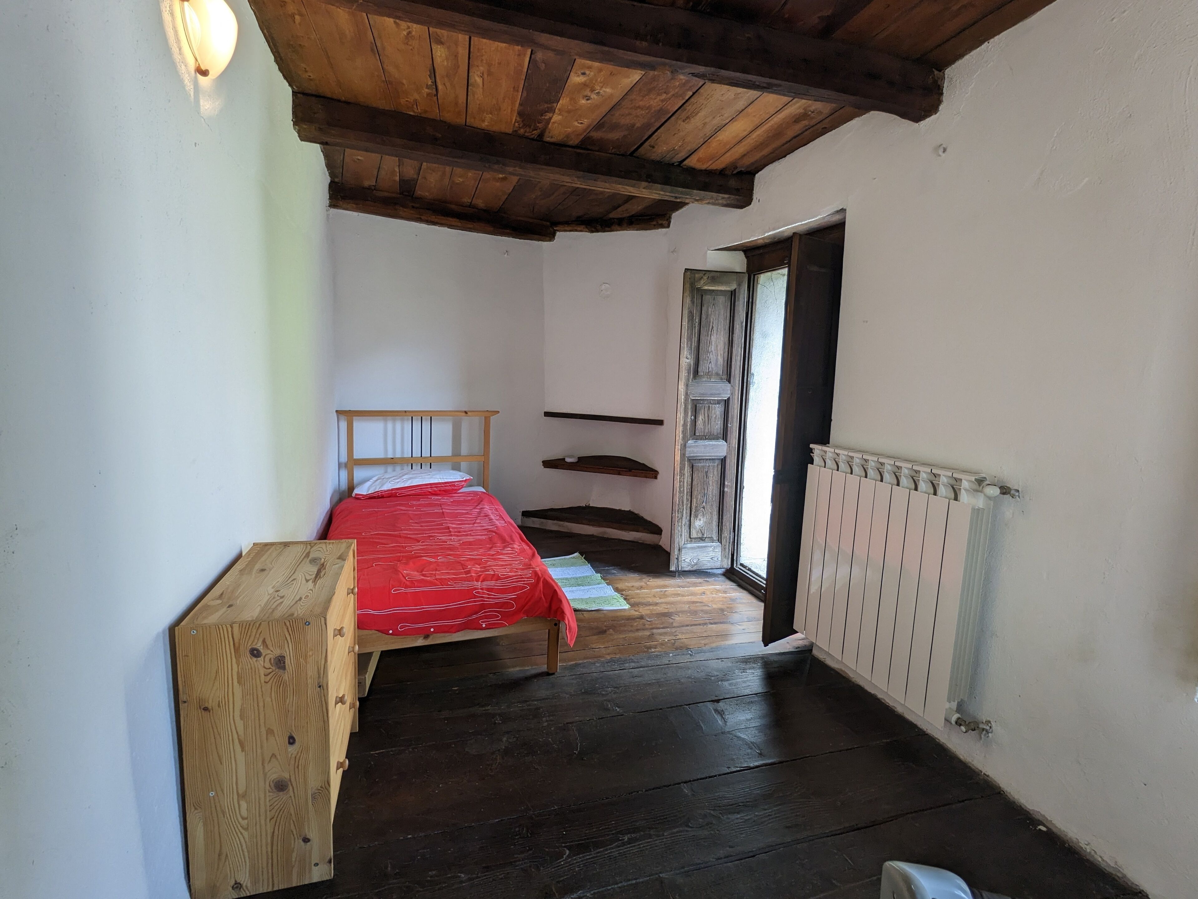 Room 5 wiith single bed and door leading to balcony with mountain views