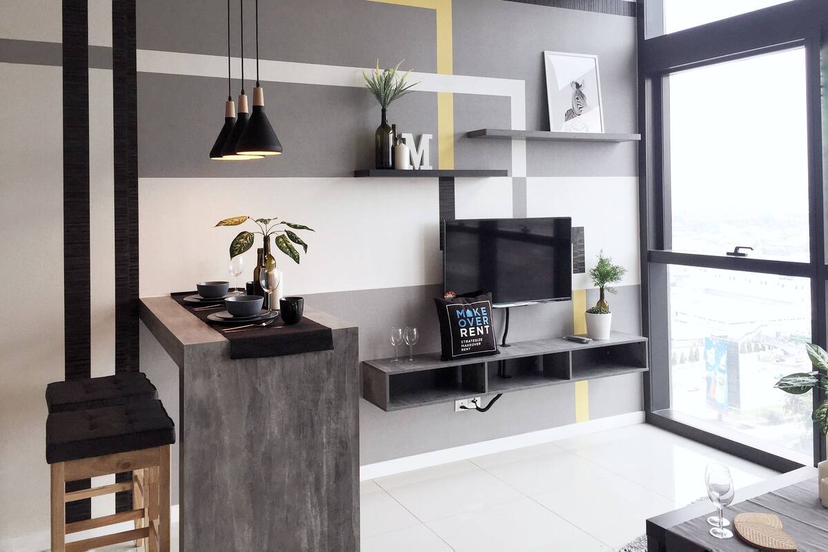 A modern living room with a large window, a TV, and a minimalist decor.
