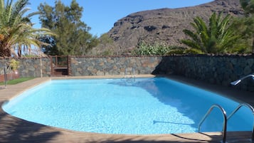 Alberca al aire libre y camastros