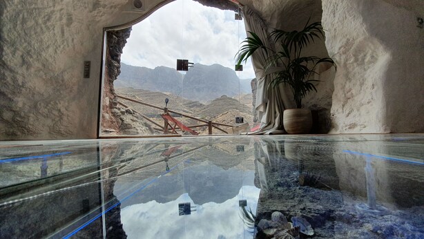 A reflective pool with a mountainous view, a potted plant, and a wooden structure. - Redondo de Guayedra (Agaete)