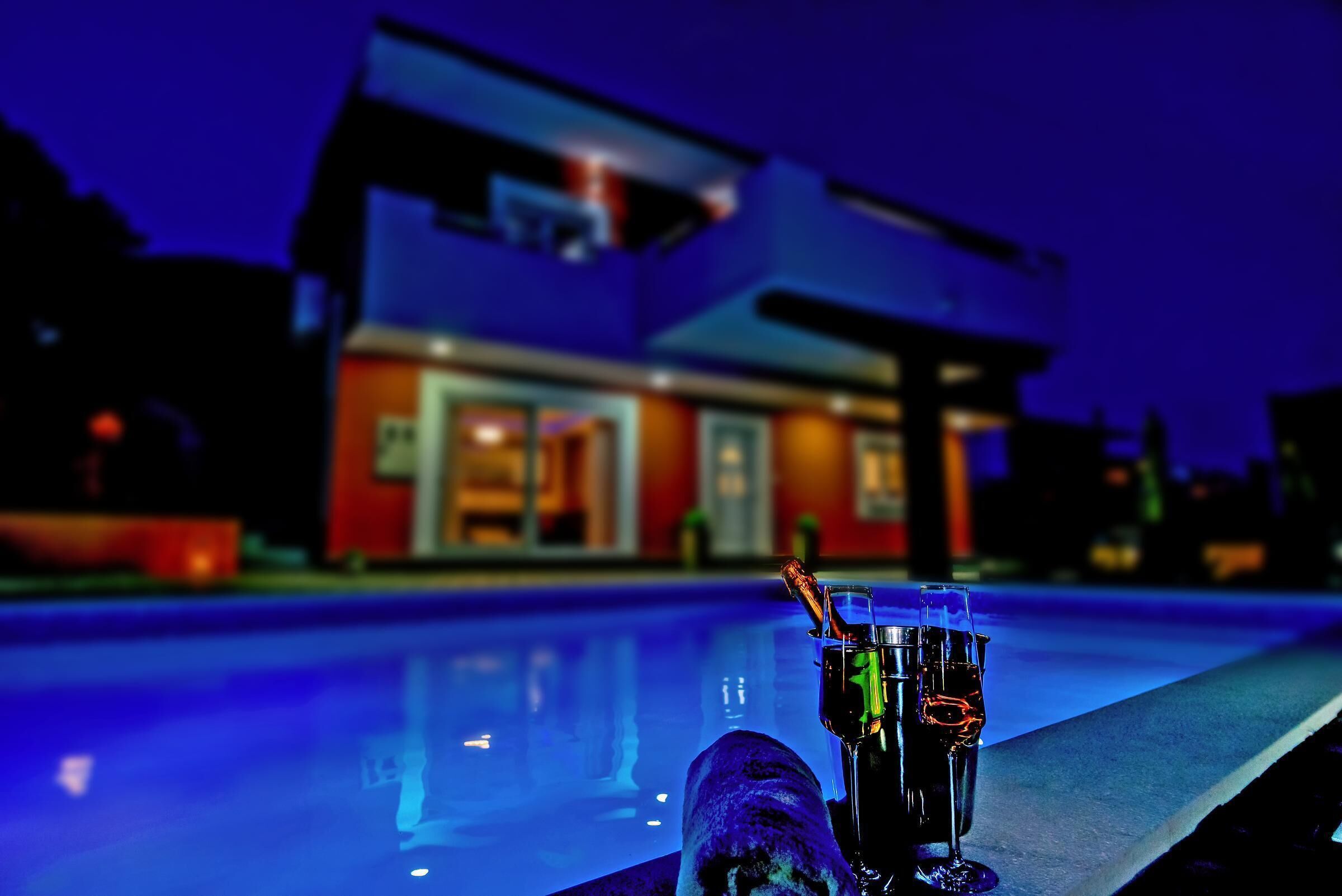 A modern house with a swimming pool in the foreground.
