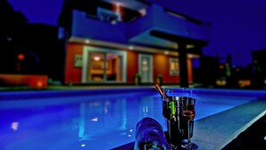 Une maison moderne avec une piscine en premier plan.