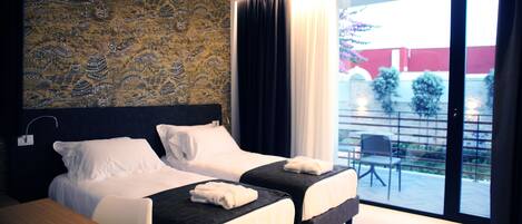 A hotel room with two beds, a large window, and a view of the outside.