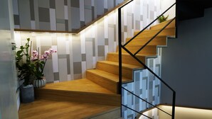 Eine moderne Treppe mit Holzstufen und einer Wand mit geometrischem Muster.