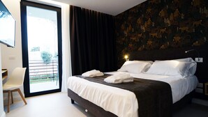 Ein modernes Hotelzimmer mit einem großen Bett, einem Schreibtisch und Blick ins Freie.