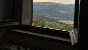 A window with a view of a landscape, including hills and a body of water. - Spectacular Views  -  Charming House in Central Todi  (Todi)