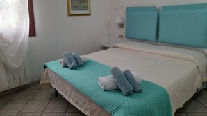 A hotel room with a bed, two pillows, a nightstand, a lamp, and a framed picture on the wall. - Aquamarine villa with garden and wifi (San Teodoro)