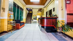 A hotel lobby with a reception desk, a staircase, and a seating area. - OYO 192 Tcc Condo - Hostel (Davao)
