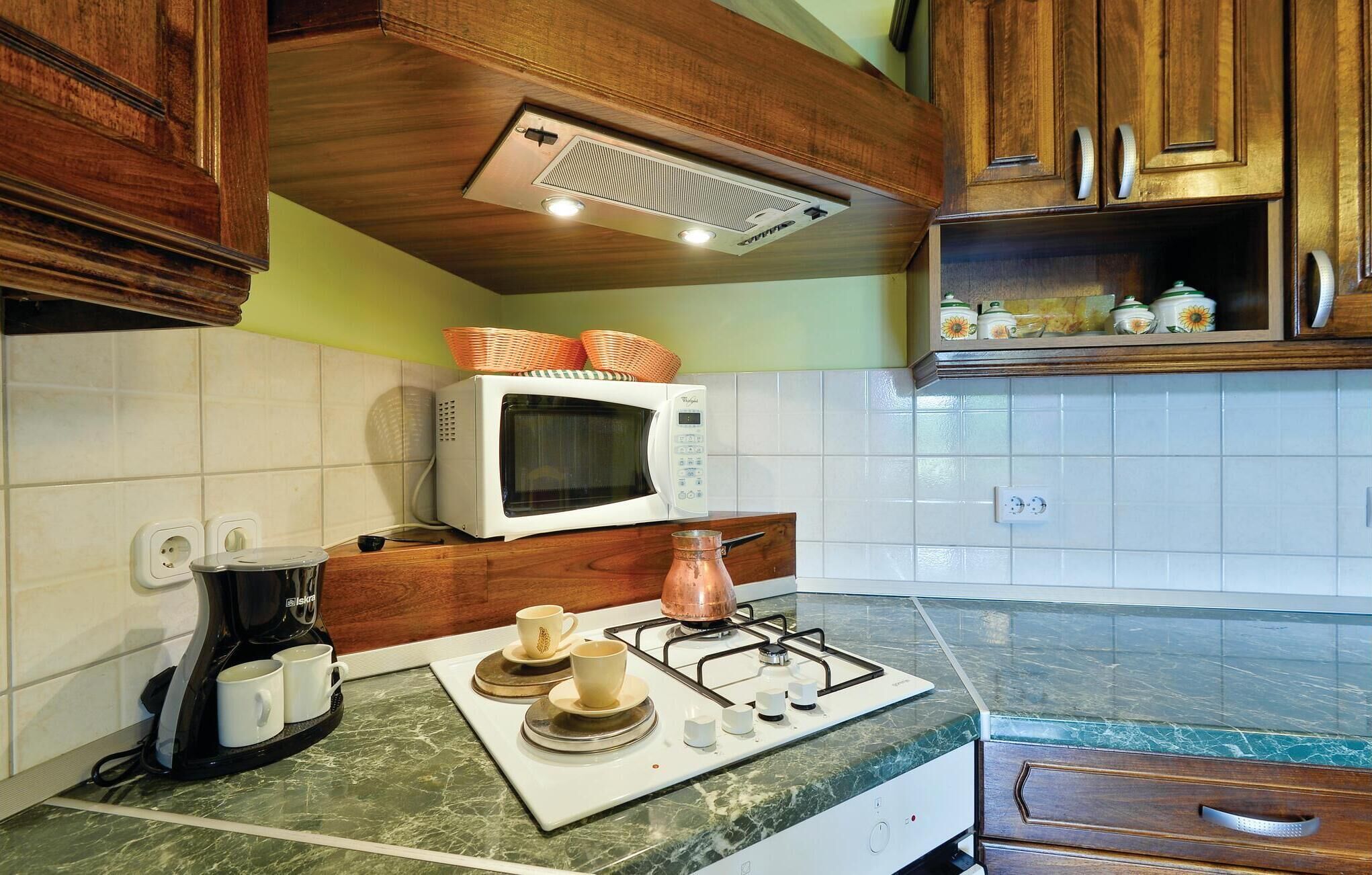 A kitchen with a microwave, coffee maker, and gas stove.