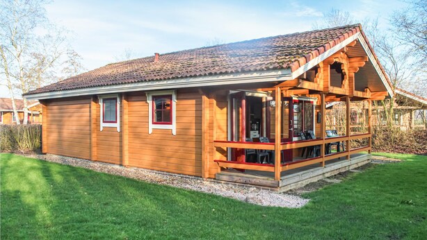 Eine Holzhütte mit Ziegeldach, einer Veranda mit Sitzgelegenheit und einem Kiesweg zum Eingang.