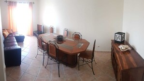A dining area with a round table, six chairs, and a wooden sideboard. - Cozy apartment in Guia (Guia)