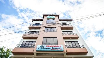 A multi-story building with a sign for 'Edmundo's Rucken Inasal Restaurant' on the ground floor.