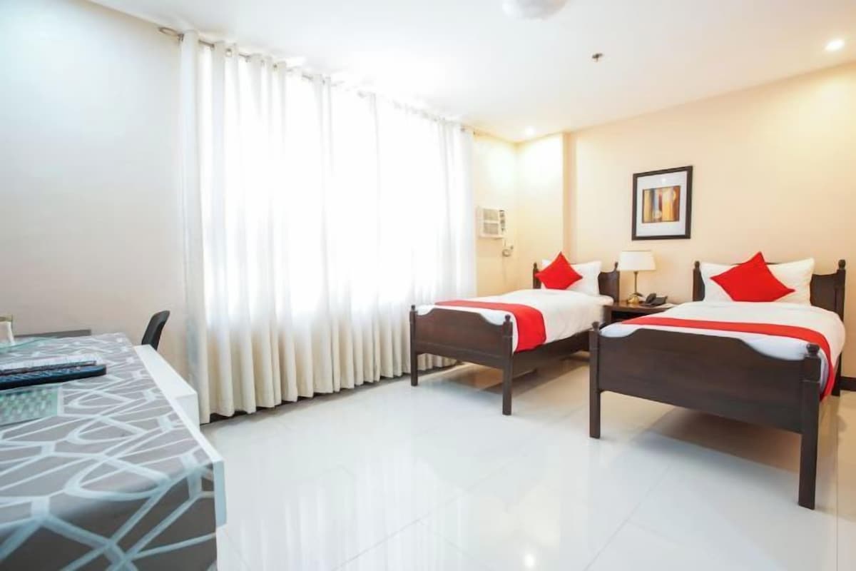Una habitación de hotel con dos camas, un escritorio y una silla.