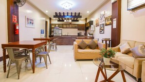 A spacious living area with a dining table, chairs, a sofa, and a coffee table.