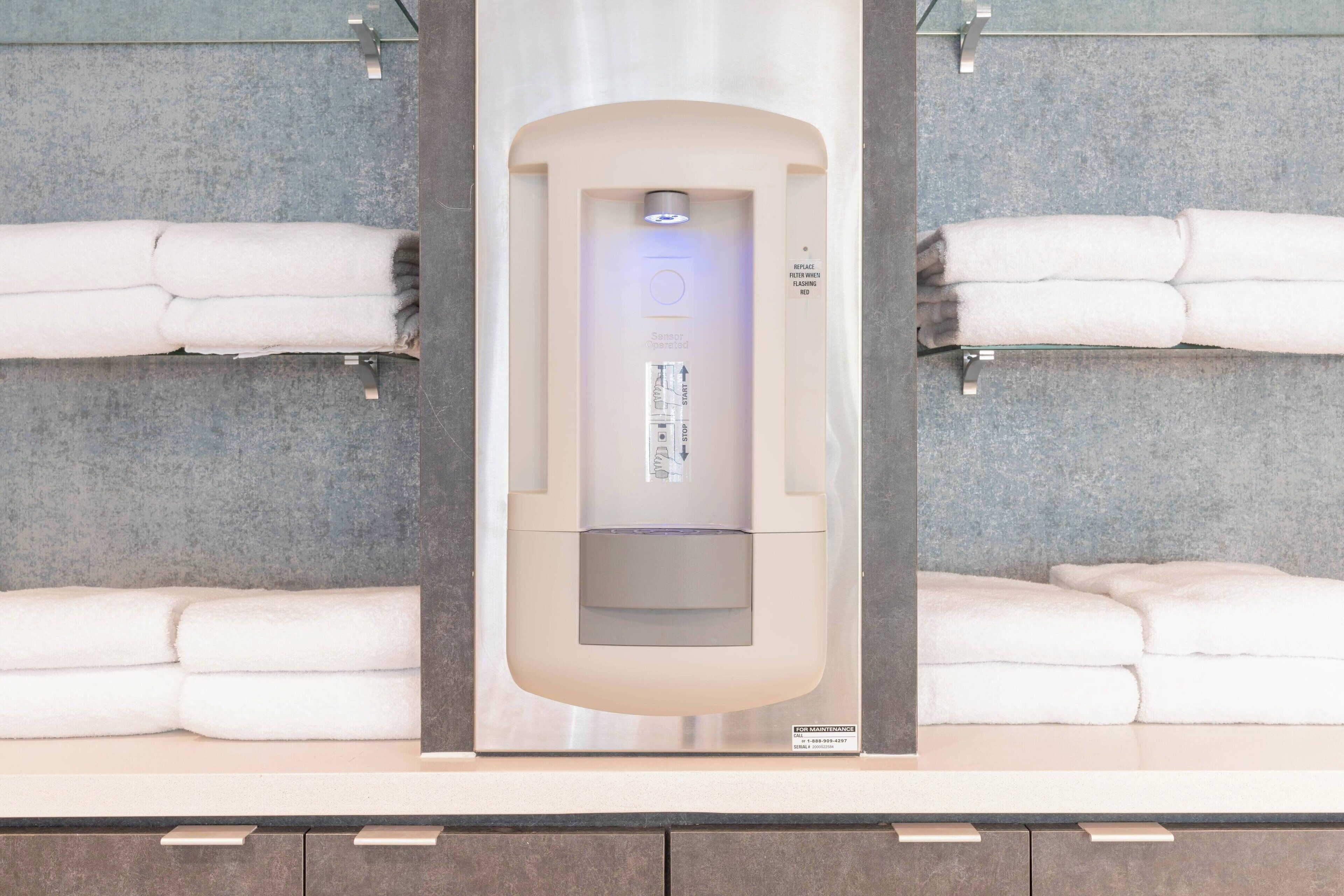 Un baño moderno con sauna integrada, dos toalleros y separador de vidrio.