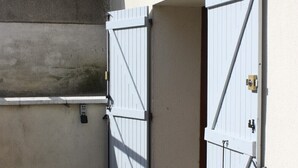 A gated entrance with a concrete wall and a tiled ground. - The Vieux Fossés duplex (Romorantin-Lanthenay)