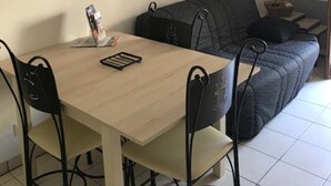 A small, modern living space with a dining table and chairs, a sofa, and a mirror on the wall. - The Vieux Fossés duplex (Romorantin-Lanthenay)