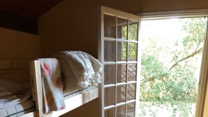 A room with a bunk bed, a window with a view of trees, and a wall-mounted heater. - Beautiful style house near the golf course (Soorts-Hossegor)